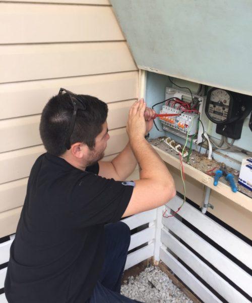Electrician working on an electrical panel outside | Featured image for About.